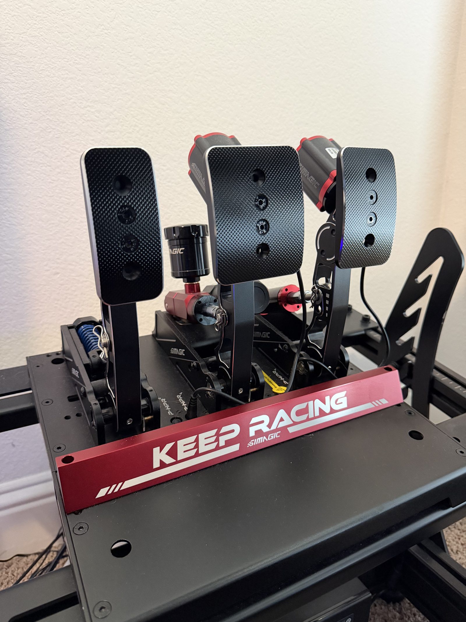 Sim racing pedal set mounted to the rig